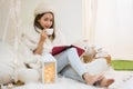 Young girl in fur sweater read book and drink tea Royalty Free Stock Photo