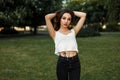 Beautiful young woman in a white T-shirt and black jeans posing Royalty Free Stock Photo