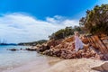 Beautiful woman sitting on a rock ocean shore Royalty Free Stock Photo