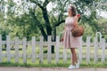 beautiful young woman with wicker basket with ripe apples