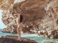 Beautiful young woman on wild rocky beach. Royalty Free Stock Photo