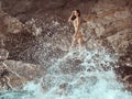 Beautiful young woman on wild rocky beach. Royalty Free Stock Photo