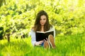 Beautiful young woman woman reading a book in the park Royalty Free Stock Photo