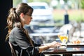 Beautiful young woman working with her laptop while having breakfast in a coffee shop. Royalty Free Stock Photo