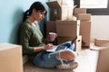 Beautiful young woman working with laptop while drinking coffee sitting on the floor at home Royalty Free Stock Photo