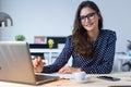 Beautiful young woman working with laptop in her office. Royalty Free Stock Photo