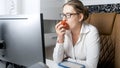 Beautiful young woman working in office and eating apple during break Royalty Free Stock Photo
