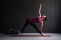 Girl standing in Utthita Trikonasana, extended triangle pose.