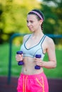Beautiful young woman working out with weights outdoors. Active girl working out with small dumbbells in the park Royalty Free Stock Photo