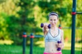 Beautiful young woman working out with weights outdoors. Active girl working out with small dumbbells in the park Royalty Free Stock Photo