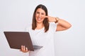 Beautiful young woman working using computer laptop over white background Pointing with hand finger to face and nose, smiling Royalty Free Stock Photo