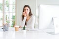 Beautiful young woman working using computer looking stressed and nervous with hands on mouth biting nails Royalty Free Stock Photo