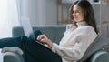 Beautiful Young Woman Works on Laptop Computer while Sitting on the Chair. Sensual Girl Wearing Royalty Free Stock Photo