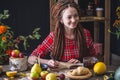 Beautiful young woman writes autumn dreams in a notebook. Fall table with flowers. Concept of autumn romantic mood