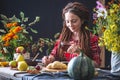 Beautiful young woman writes autumn dreams in a notebook. Fall table with flowers. Concept of autumn romantic mood Royalty Free Stock Photo