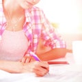 Beautiful young woman writing something in her note pad Royalty Free Stock Photo