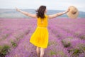 Beautiful young woman in yellow dress walking and having fun in purple flower lavander field