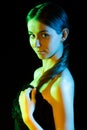 Beautiful young woman in yellow, green and blue lights Royalty Free Stock Photo