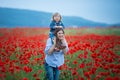 Beautiful young woman with child girl in poppy field. happy family having fun in nature. outdoor portrait in poppies. mother with Royalty Free Stock Photo