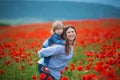 Beautiful young woman with child girl in poppy field. happy family having fun in nature. outdoor portrait in poppies. mother with Royalty Free Stock Photo