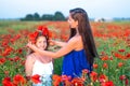 Elegant young woman with child girl in poppy field, happy family having fun in nature, summer time Royalty Free Stock Photo