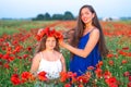 Elegant young woman with child girl in poppy field, happy family having fun in nature, summer time Royalty Free Stock Photo