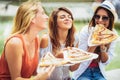 Beautiful young women eating pizza after shopping, having fun together Royalty Free Stock Photo