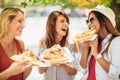 Beautiful young women eating pizza after shopping, having fun together Royalty Free Stock Photo