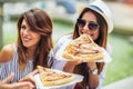 Beautiful young women eating pizza after shopping, having fun together Royalty Free Stock Photo