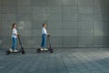 Beautiful young women is enjoying sunny summer day while riding around the city on electro kick scooters. Lifestyle. Royalty Free Stock Photo