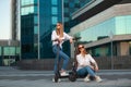 Beautiful young women is enjoying sunny summer day while riding around the city on electro kick scooters. Lifestyle. Royalty Free Stock Photo