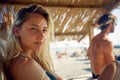 Beautiful young blonde woman enjoying time on beach. Couple on summer vacation together. Holiday, fun, lesiure, lifestyle concept