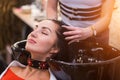 Beautiful young woman with hairdresser washing head at hair salon. Spa, care, beauty and people Royalty Free Stock Photo