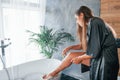 Shaves legs. Beautiful young woman have free time at home in the bath. Royalty Free Stock Photo