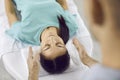 Young woman relaxing during holistic therapy session with Reiki healing specialist