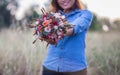 Beautiful young women holding a flower in a field