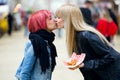 Beautiful young women kissing on the street.