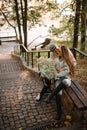 young woman and man sitting on bench outdoor. Guy kisses girlfriend. Royalty Free Stock Photo