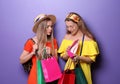 Beautiful young women with new shoes and shopping bags on color background Royalty Free Stock Photo
