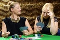 Beautiful young women playing cards or poker in a backroom or casino Royalty Free Stock Photo