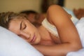 Beautiful dreamer. A beautiful young woman sleeping peacefully with her husband behind her. Royalty Free Stock Photo