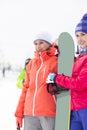 Beautiful young women with snowboard looking away Royalty Free Stock Photo