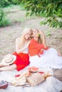 Beautiful young women talking, smiling and gesturing while having picnic outdoors at park. Royalty Free Stock Photo