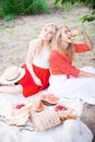 Beautiful young women talking, smiling and gesturing while having picnic outdoors at park. Royalty Free Stock Photo