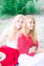 Beautiful young women talking, smiling and gesturing while having picnic outdoors at park. Royalty Free Stock Photo