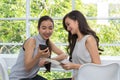 Beautiful young women using digital mobile phone and tablet in c Royalty Free Stock Photo