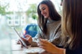 Beautiful young women using digital tablet in coffee shop. Royalty Free Stock Photo