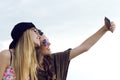 Beautiful young women using mobile phone in the street. Royalty Free Stock Photo