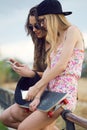 Beautiful young women using mobile phone in the street. Royalty Free Stock Photo