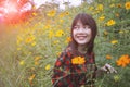 Beautiful younger asian woman toothy smiling face with happiness emotion standing in yellow cosmost flower field Royalty Free Stock Photo